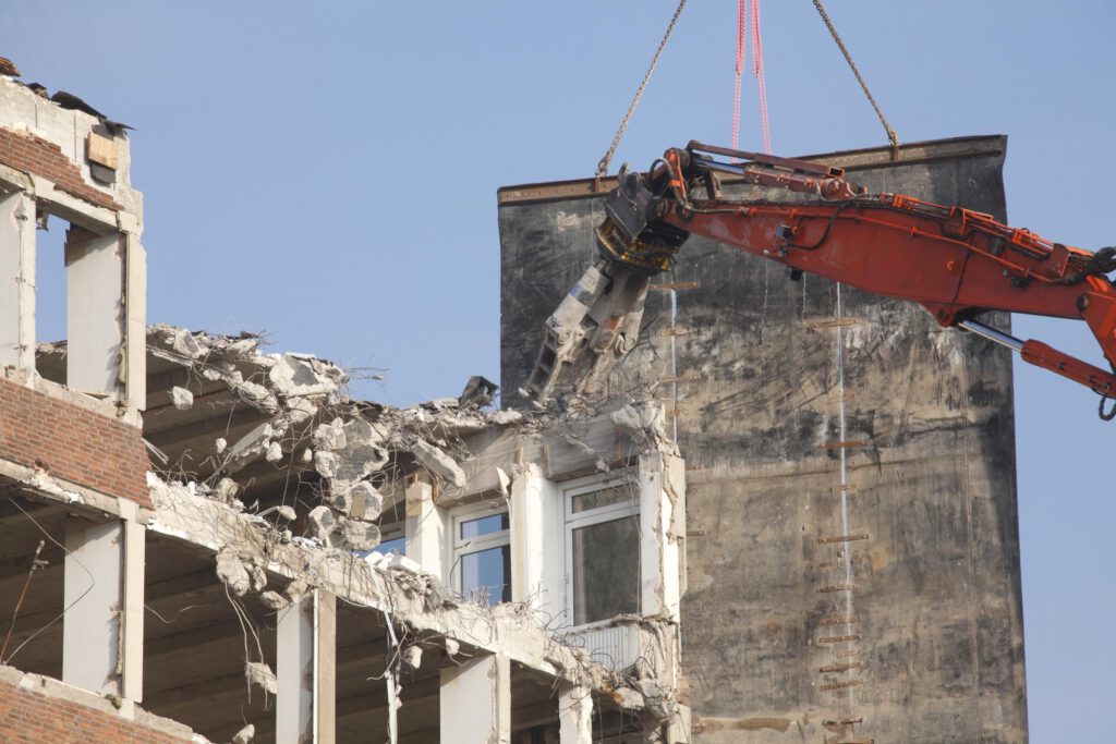 building being destroyed by the excavator