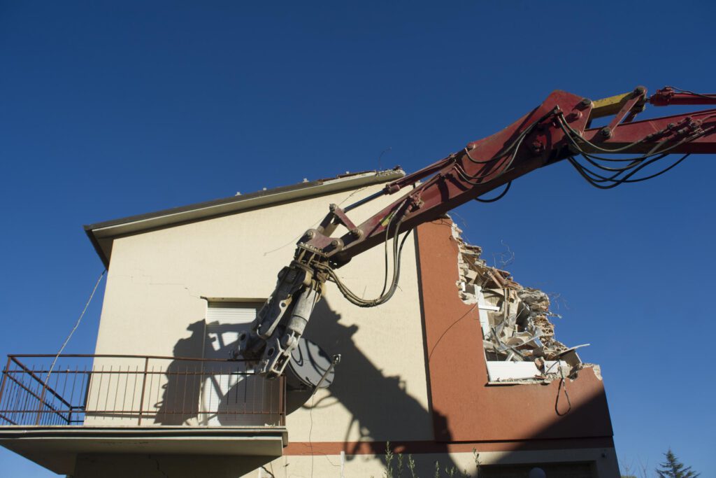 excavator destroying the house